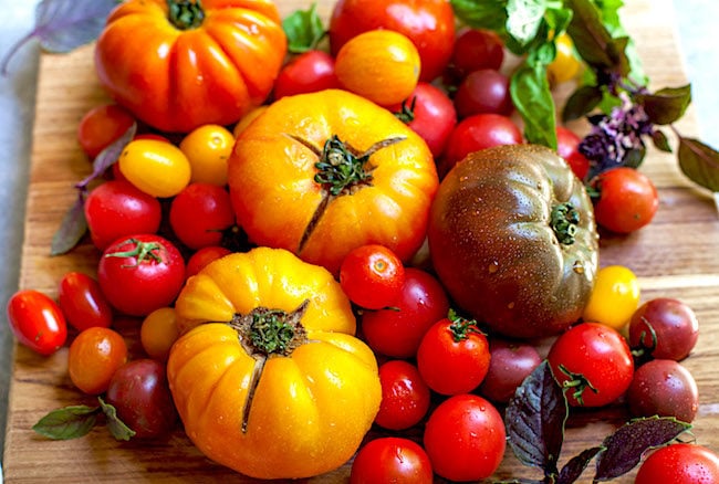 Fresh garden tomatoes on cutting board.