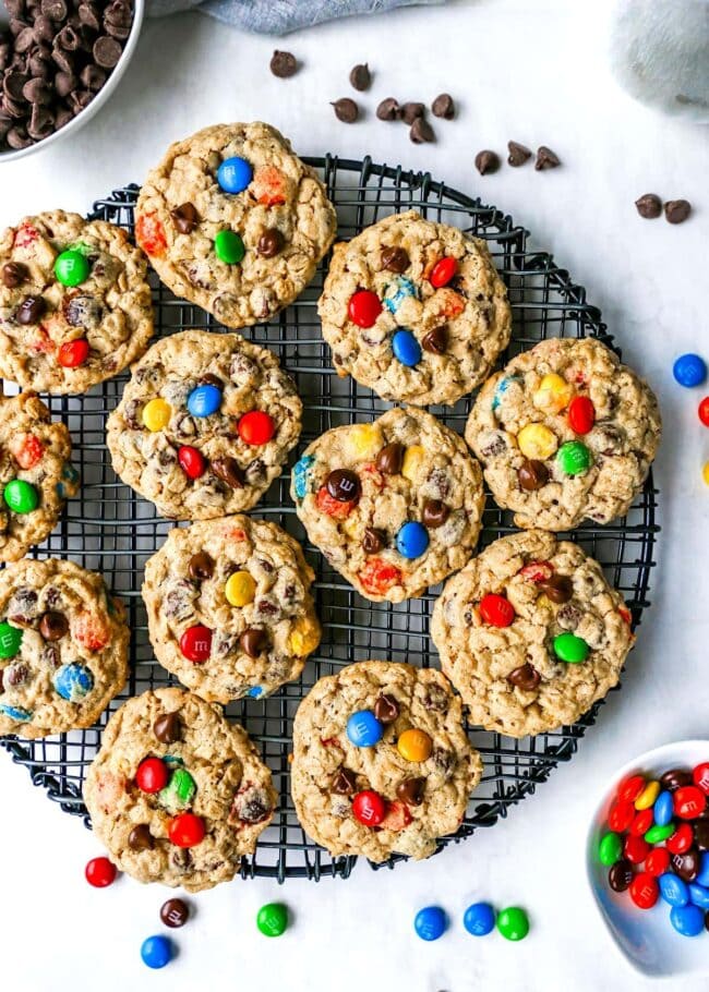 Monster Cookies on cooling rack with chocolate chips and M&M's.