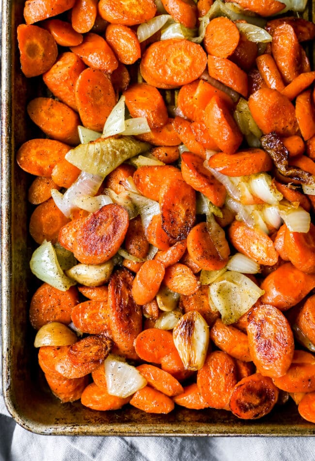roasted carrots and onions on baking sheet for carrot ginger soup