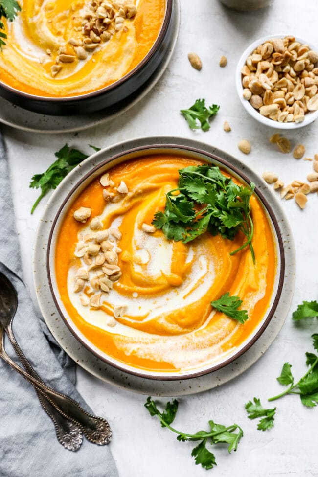 Carrot Ginger Soup with coconut milk, cilantro, and peanuts in bowl