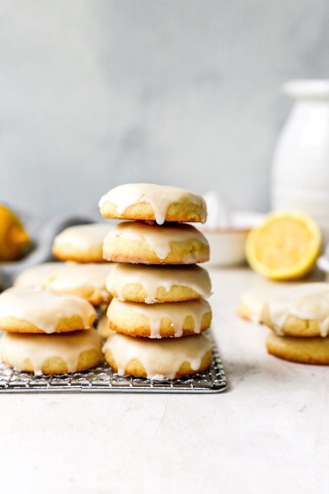 glazed lemon cookies stacked on a cooling rack