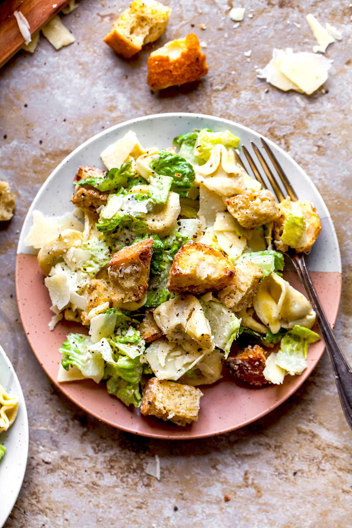 Caesar Salad with Tortellini  on plate with fork. 