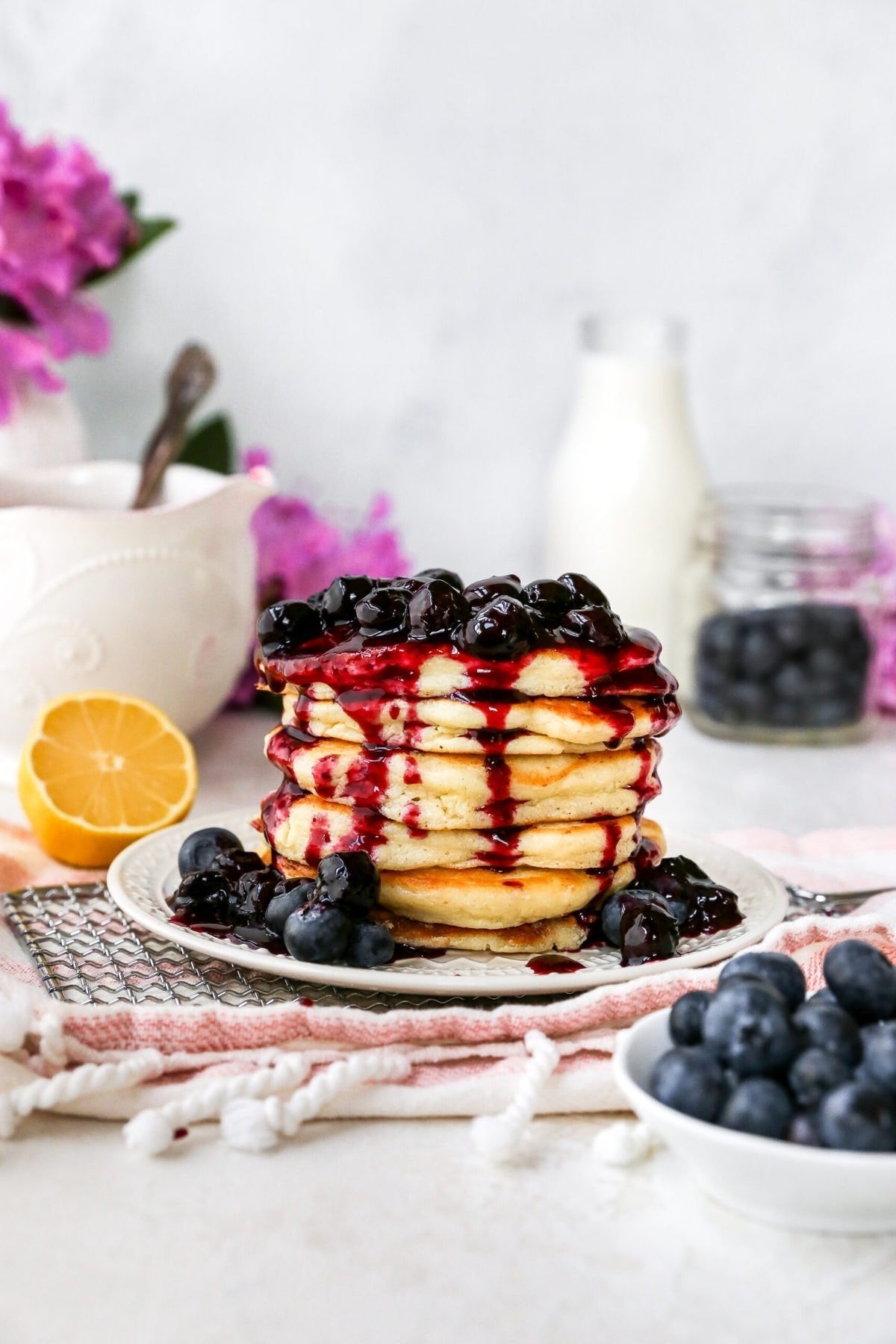 stack of lemon ricotta pancakes with blueberry sauce on plate. 