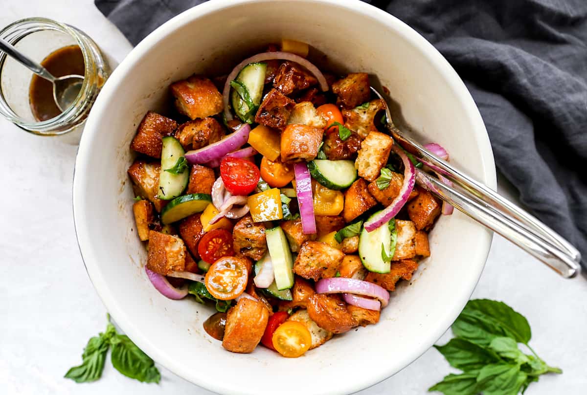 Tossing Panzanella Salad in a bowl 