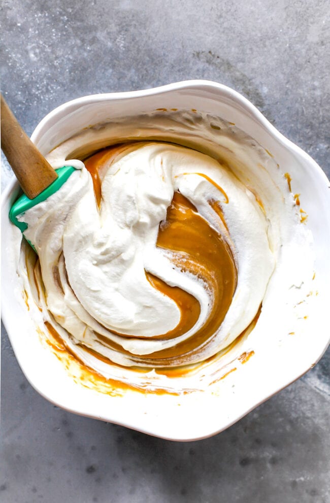 Whipped cream and Biscoff mixing together in bowl for Biscoff ice cream