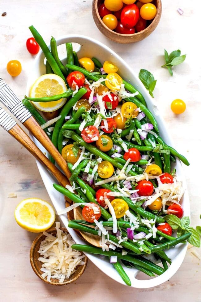 Green bean salad on platter with serving spoons