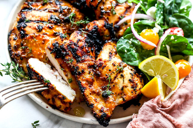 Honey mustard chicken on plate with a bite on a fork