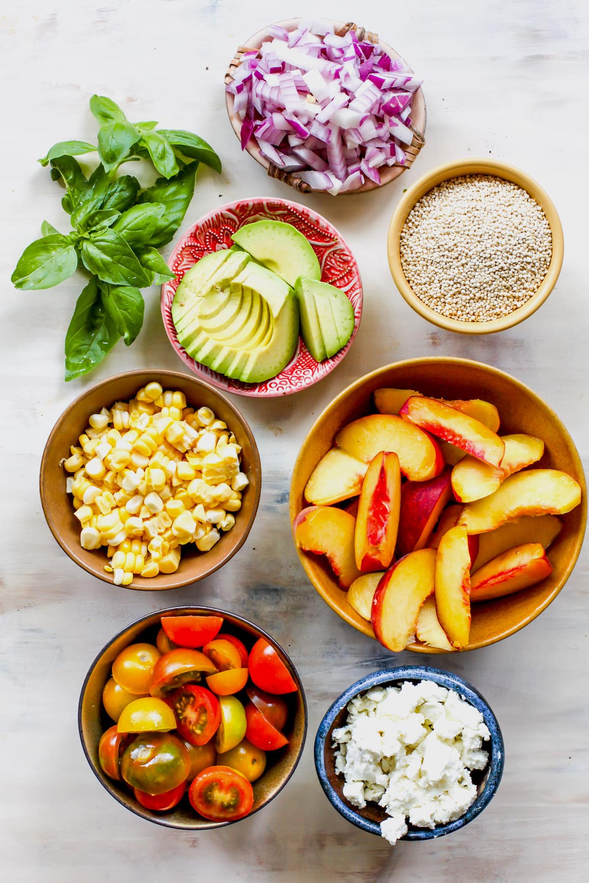 summer quinoa salad ingredients in bowls. 