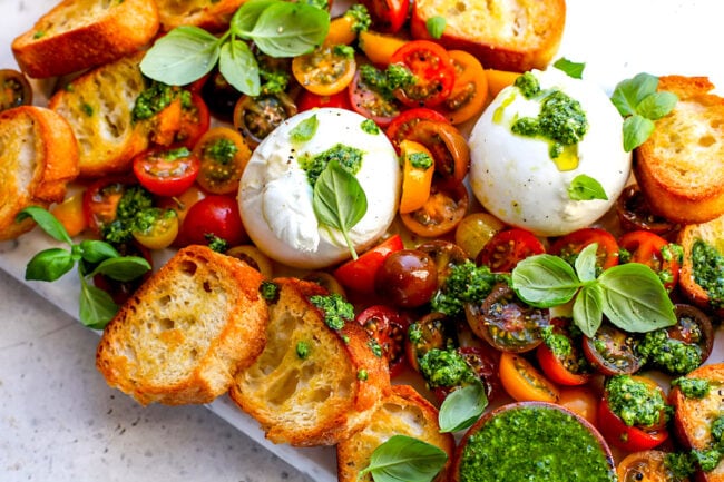 burrata with tomatoes, pesto, and grilled bread with fresh basil 