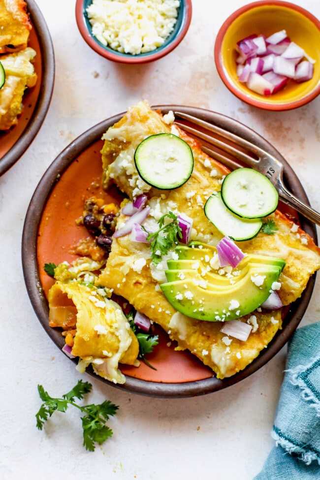 corn and zucchini enchiladas on plate with fork
