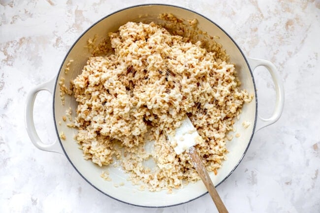 making rice krispie treats in pan with spatula.