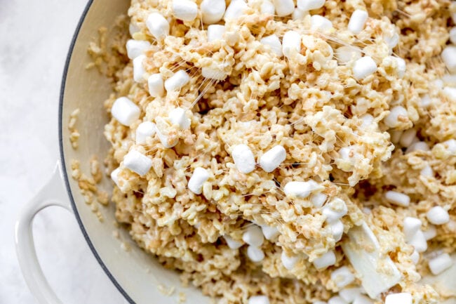 stirring rice krispie treats in pan