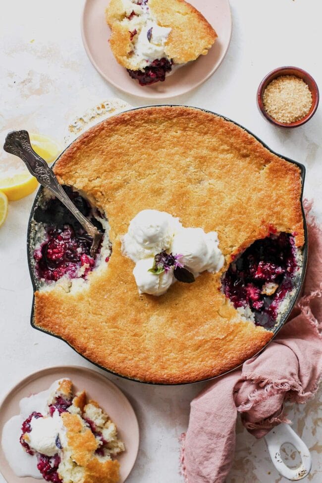 blackberry cobbler in skillet with ice cream