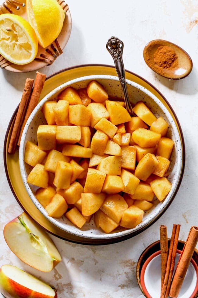 skillet cinnamon apples in bowl with spoon.