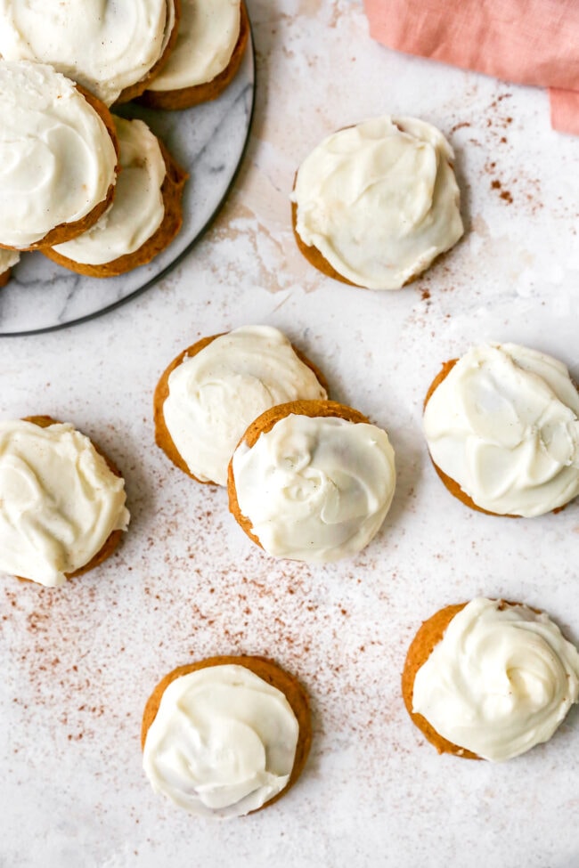 Soft pumpkin cookies with cream cheese frosting with a dusting of cinnamon.
