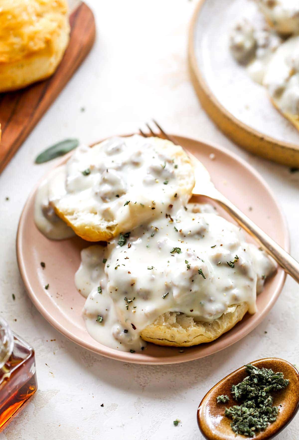 biscuits and gravy on plate with fork.