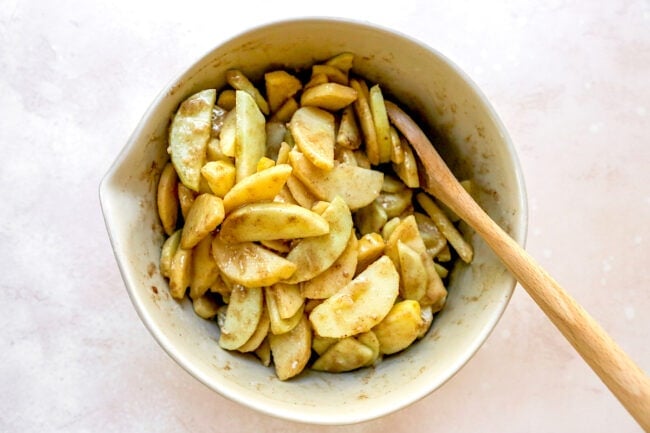 apple crumble filling in bowl with wooden spoon. 