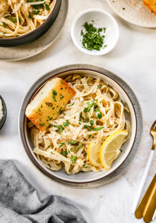 Fettuccine Alfredo in bowl with garlic bread