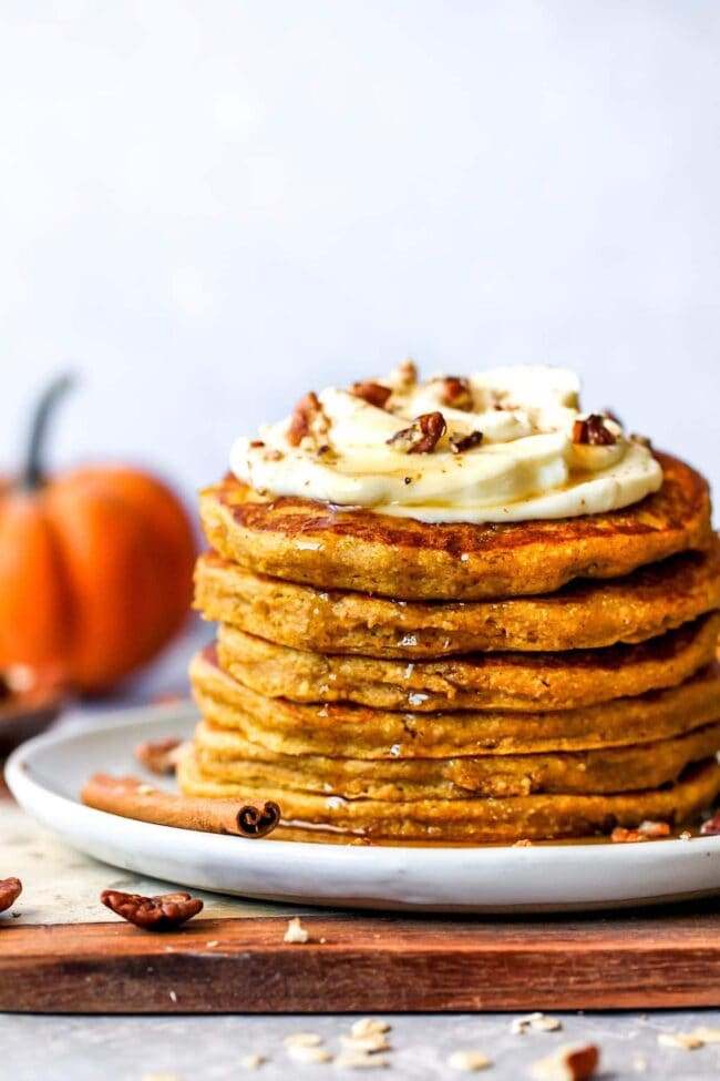 healthy pumpkin pancakes with whipped cream and maple syrup