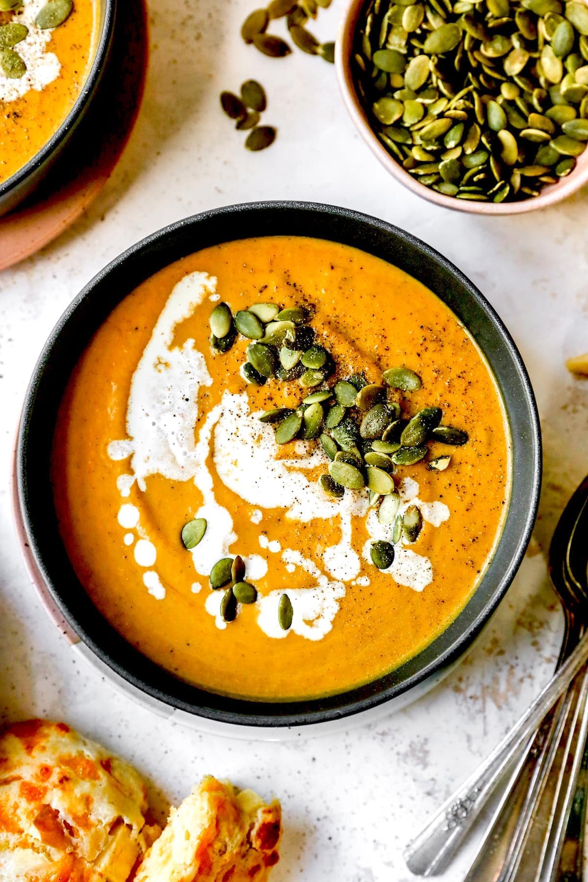 Pumpkin Soup in bowl with cream and pumpkin seeds. 