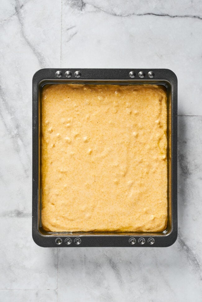 A baking dish filled with uncooked cornbread batter
