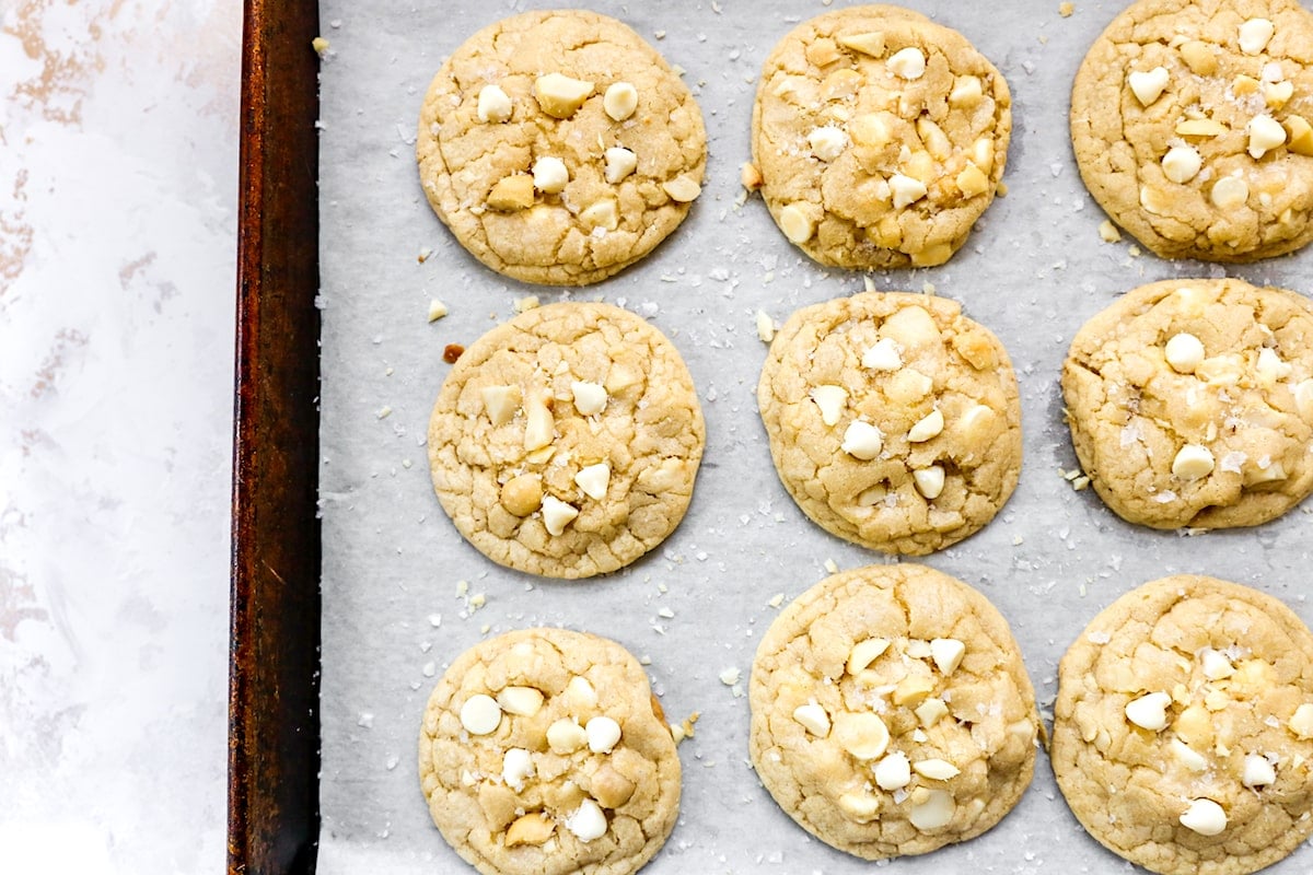 white chocolate macadamia nut cookies on baking sheet with parchment paper. 