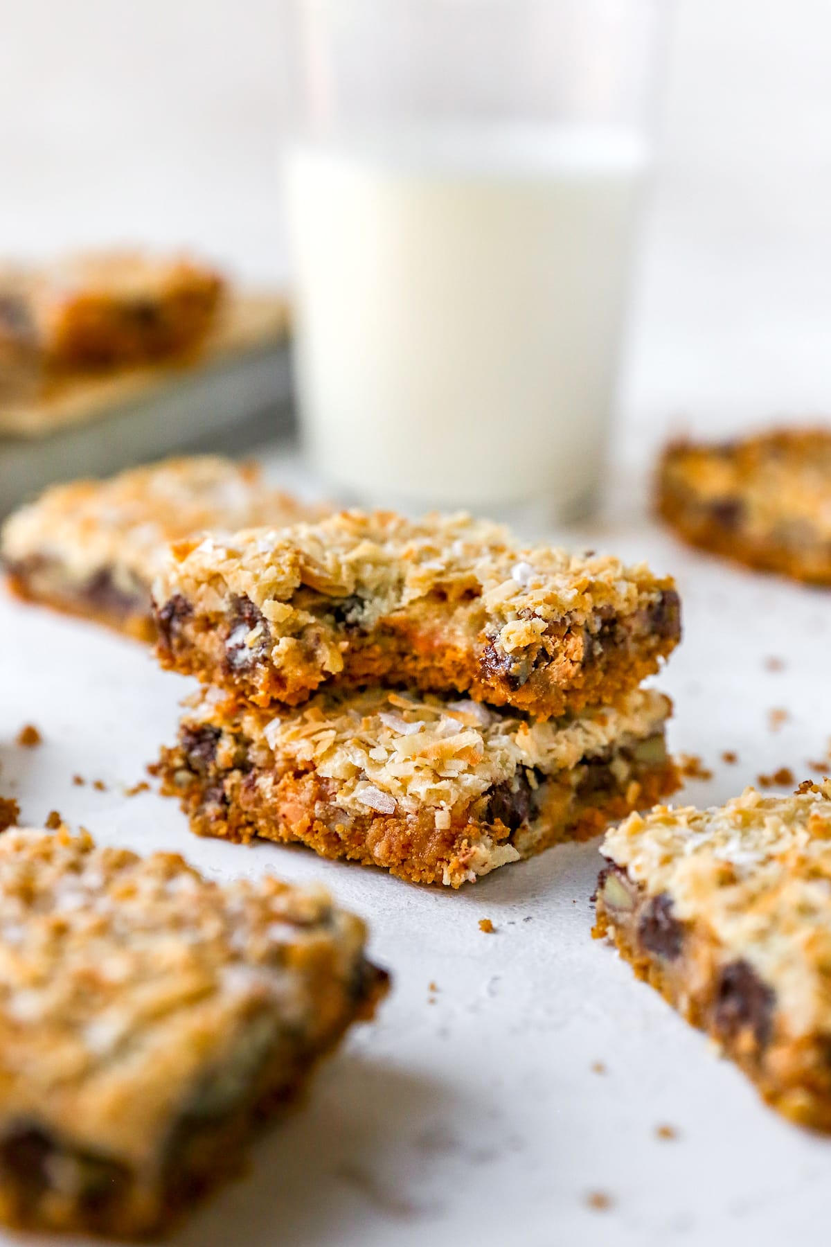 magic cookie bars stacked on top of each other and top bar has a bite out of it. 