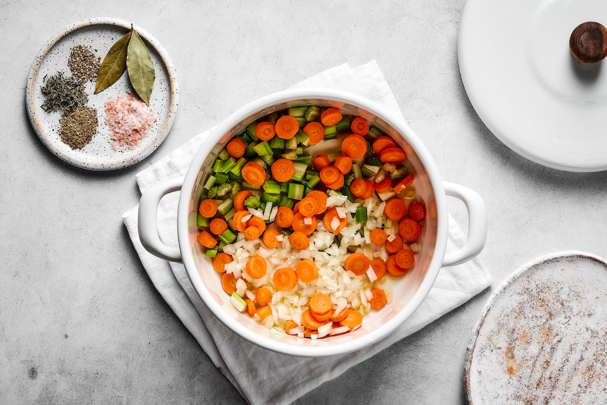 Chopped carrots, celery, and onions combined in a saucepan.