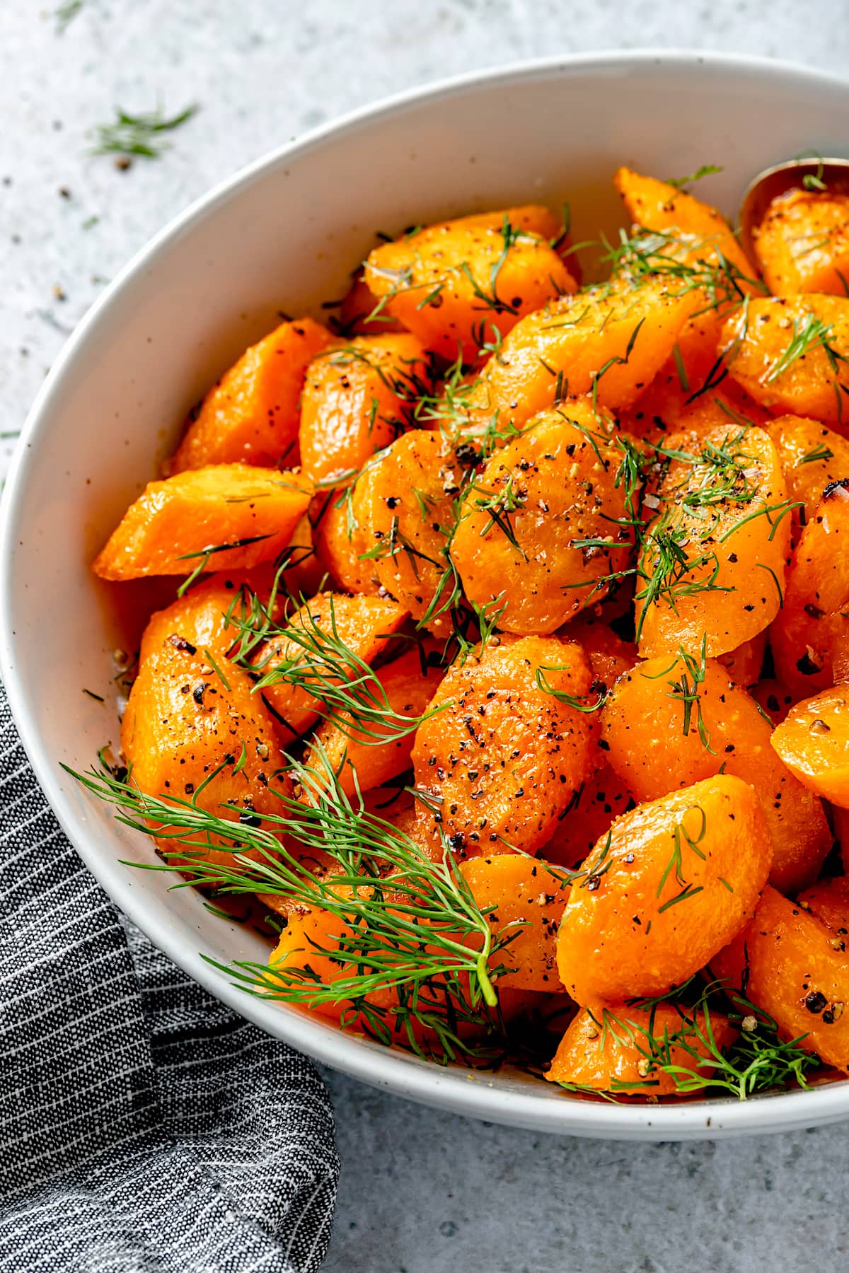 oven roasted carrots in bowl with dill.