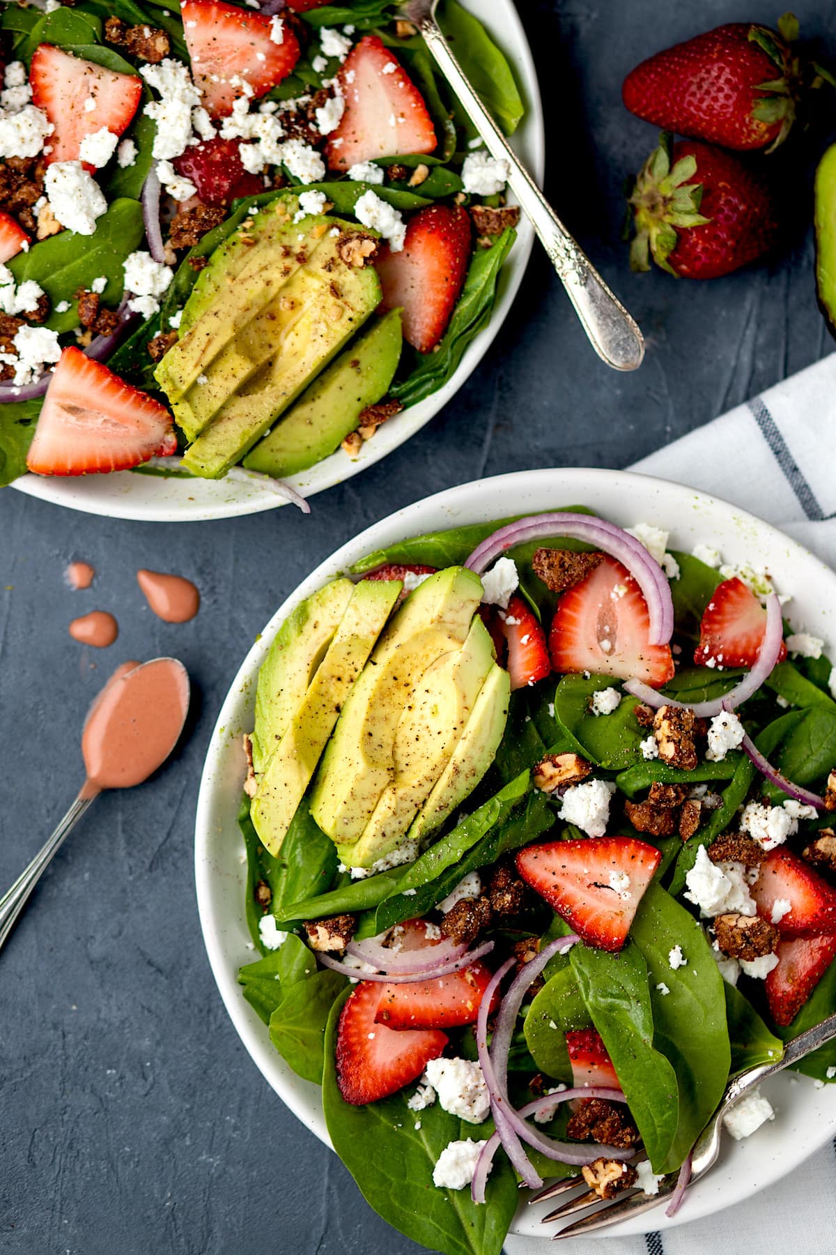 strawberry spinach salad on plates with strawberry dressing.