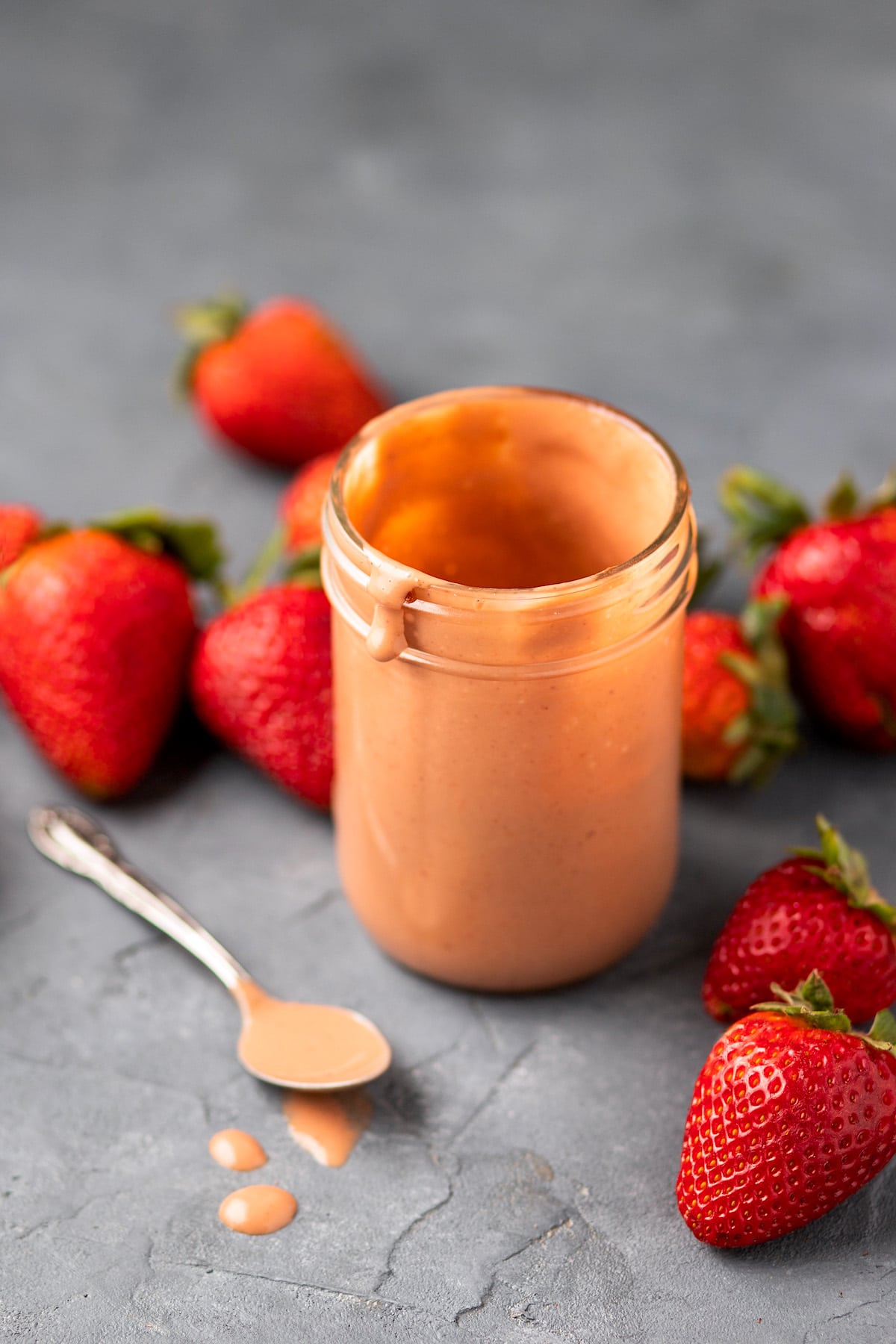 strawberry balsamic dressing for strawberry spinach salad in jar with spoon on side. 