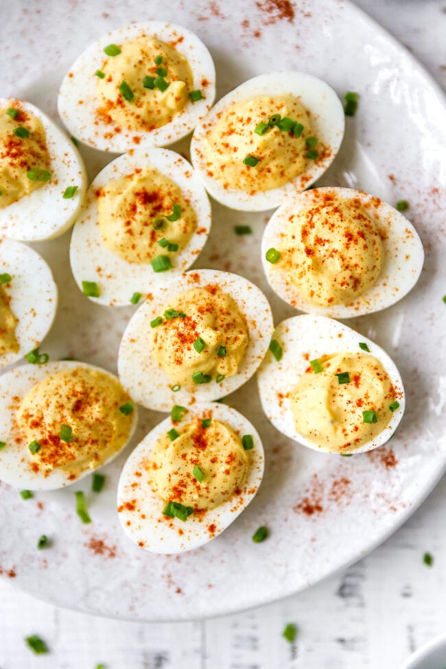 deviled eggs with paprika and chives on plate