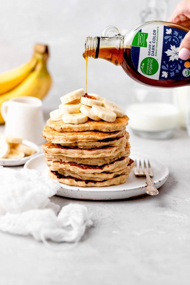 stack of banana pancakes with maple syrup