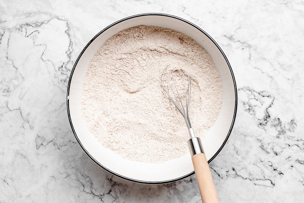 dry ingredients being whisked together in bowl. 