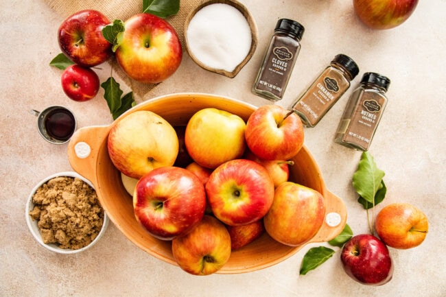 apples in a bowl and ingredients to make apple butter. 