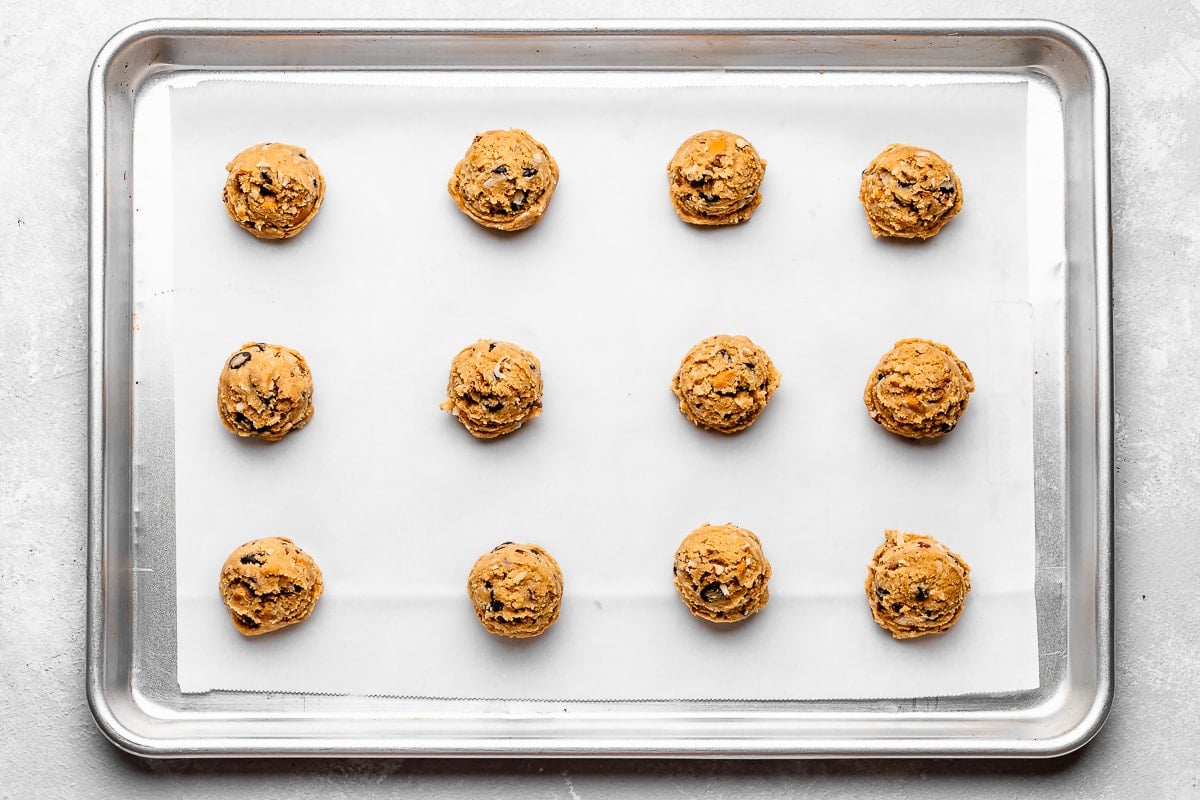 cookie dough balls on cookie sheet with parchment paper. 