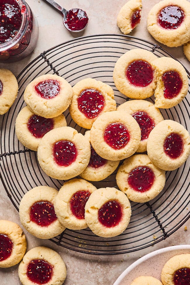 thumbprints cookies with raspberry jam on wire cooling rack.