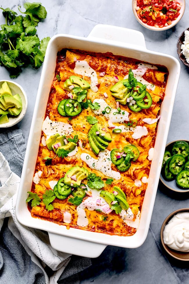 beef enchiladas in pan with toppings