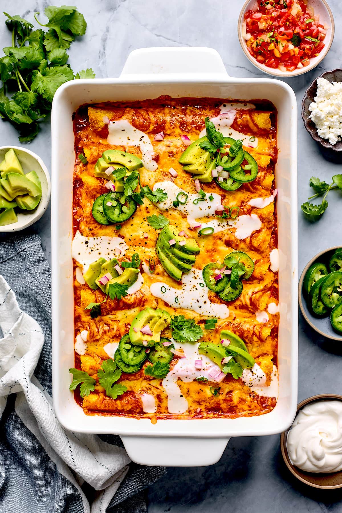 beef enchiladas in pan with toppings. 