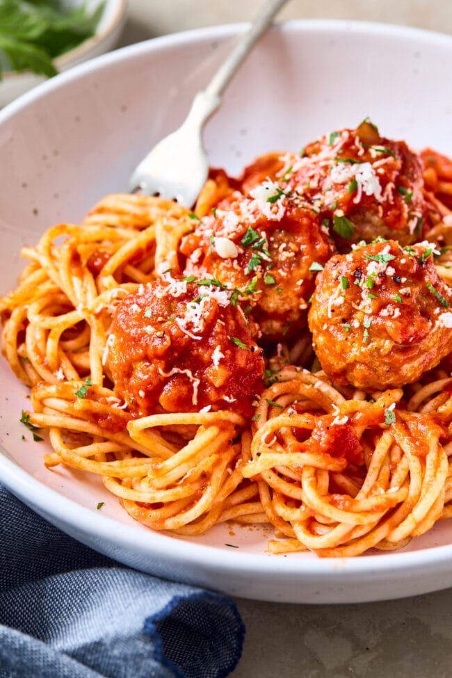 spaghetti and chicken meatballs in bowl with fork