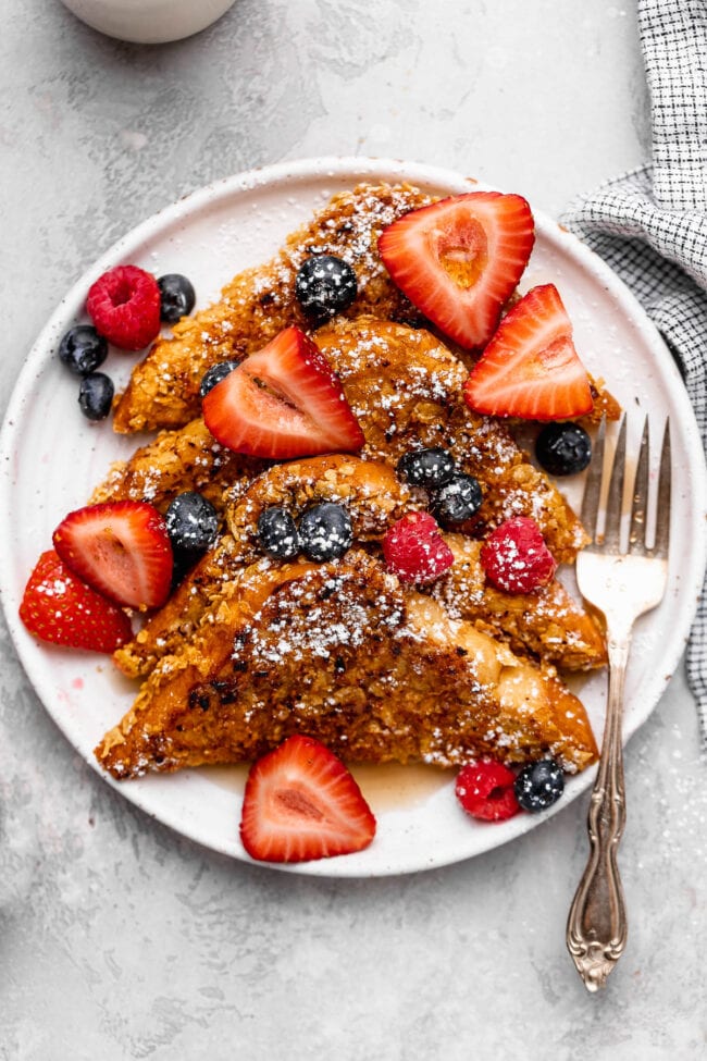 pieces of crunchy French toast on plate with berries