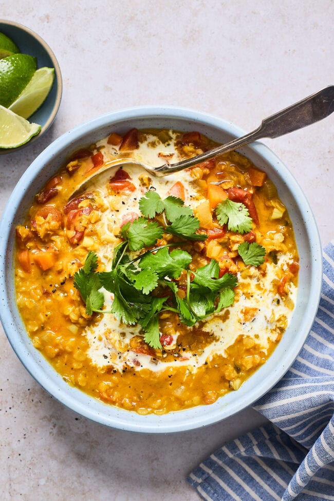 curry lentil soup in bowl with cilantro and coconut milk 