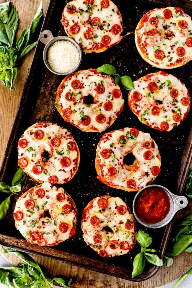 pizza bagels on baking sheet with pepperoni and cheese