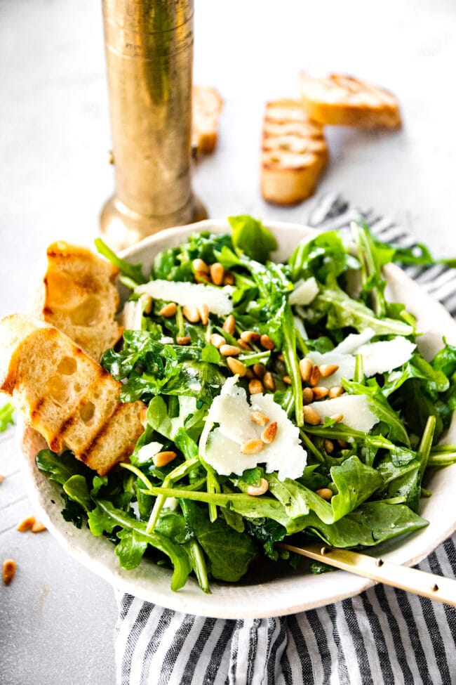 arugula salad in bowl with toasted bread