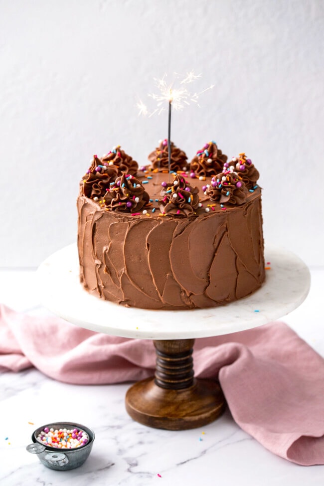 yellow cake with chocolate buttercream frosting and a candle