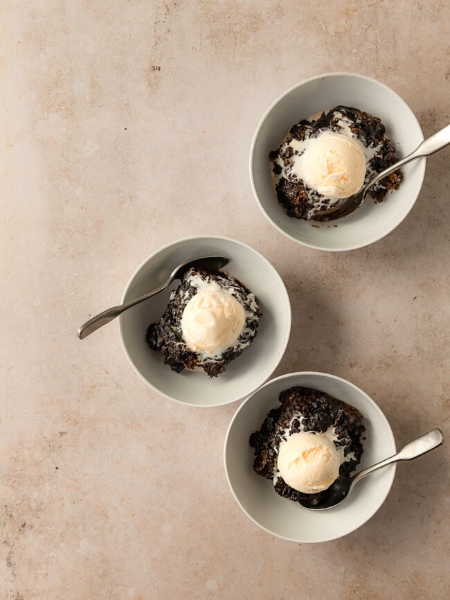 three bowls of chocolate pudding cake with vanilla ice cream