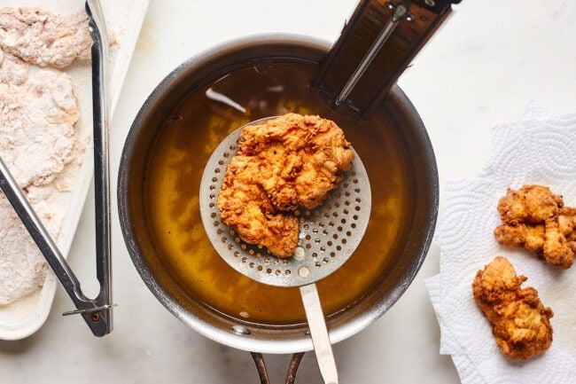 frying chicken in pot of oil