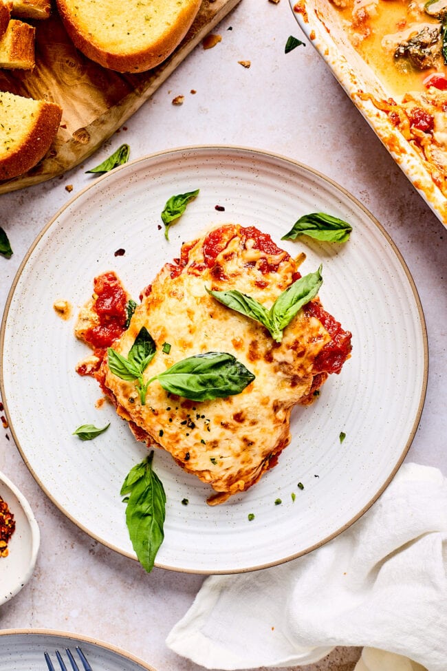 piece of cheesy polenta lasagna on plate with basil 