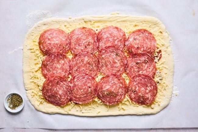 pizza dough with cheese, pepperoni, and salami to make stromboli