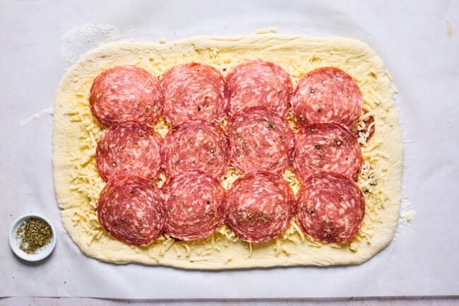 pizza dough with cheese, pepperoni, and salami to make stromboli